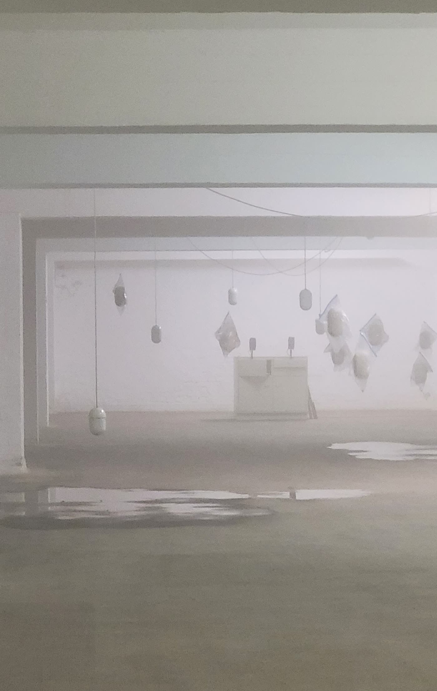 Übersicht des Ausstellungsraums mit mehreren hängenden Objekten