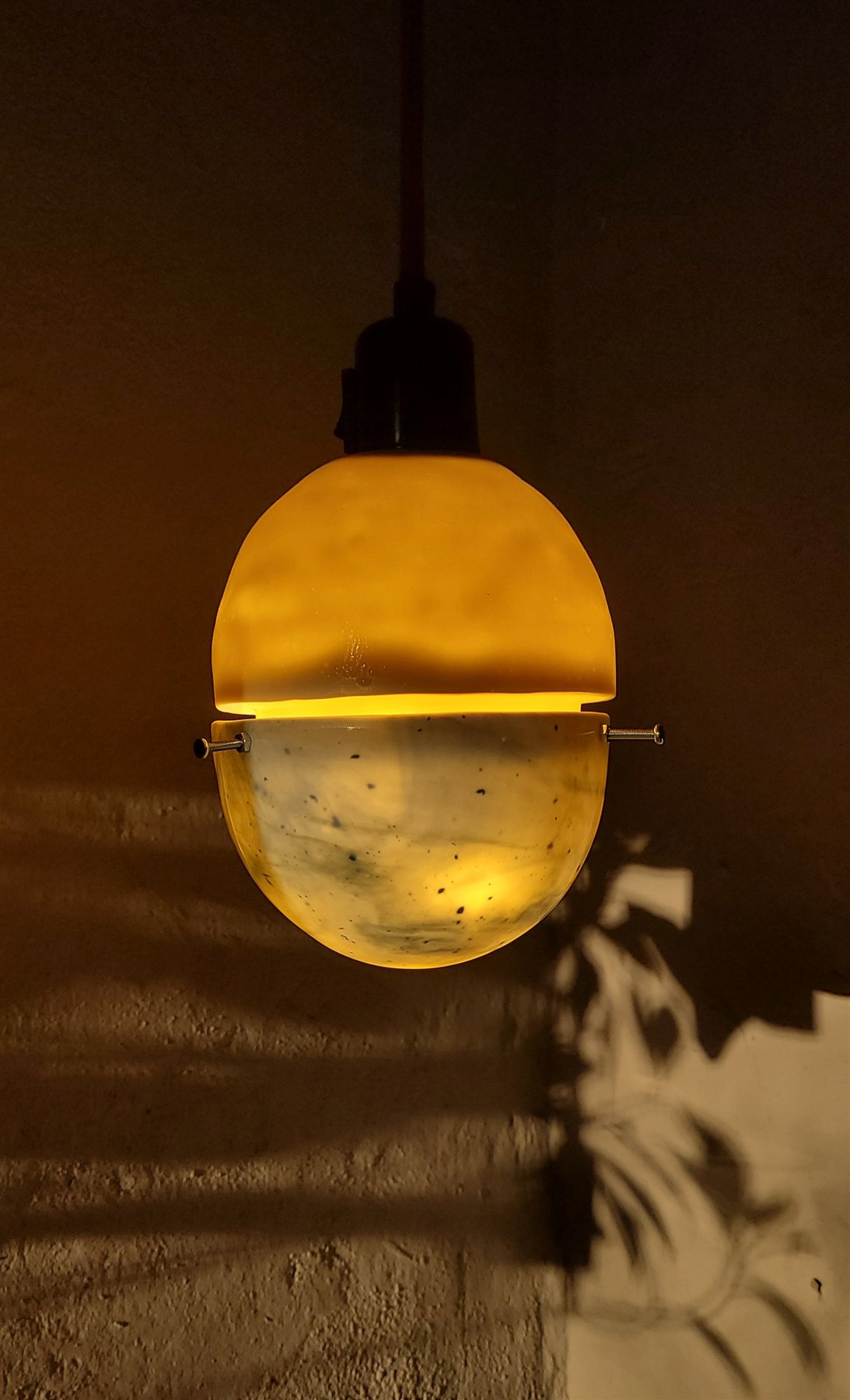 Panta-Lampe mit Pflanzenschatten an der Wand